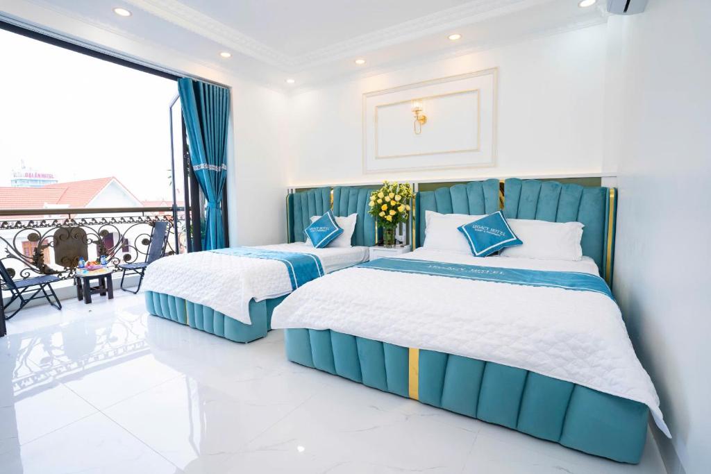 two beds in a bedroom with a balcony at Legacy Hotel in Kỳ Vĩ