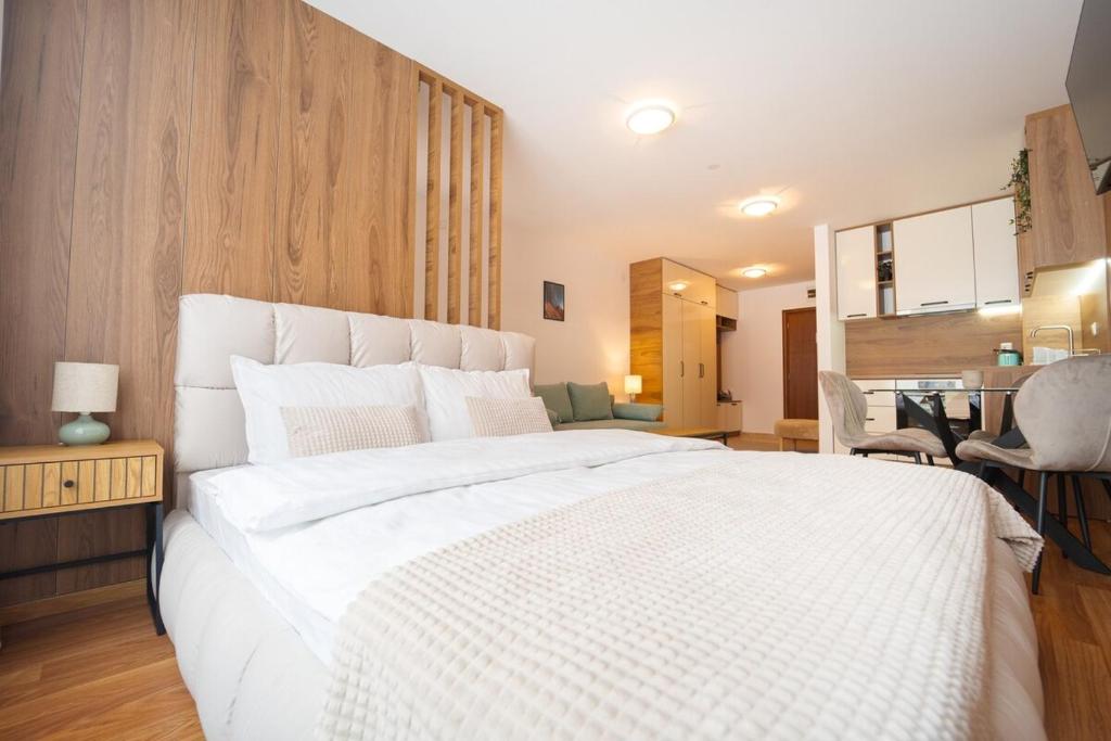 una camera da letto con un grande letto bianco in una stanza di Pirin Sense Studio - SPA - FREE Parking a Bansko