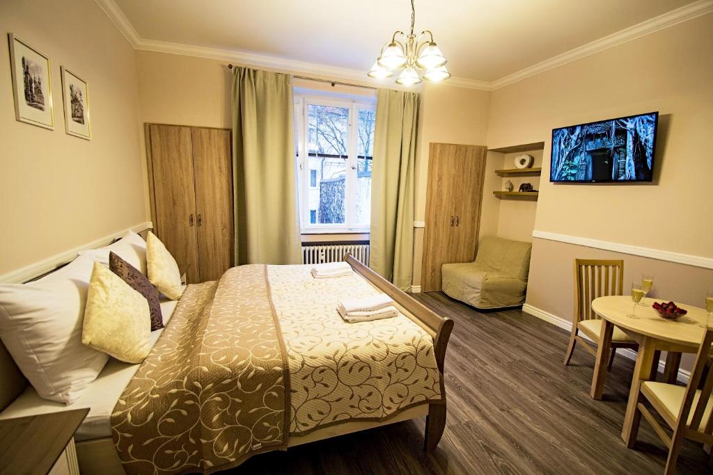 プラハにあるChampagne Studio with Saunaのベッドとテーブルが備わるホテルルームです。
