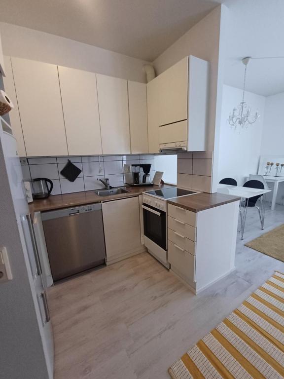 an empty kitchen with white cabinets and a table at Royal Katariina in Kokkola