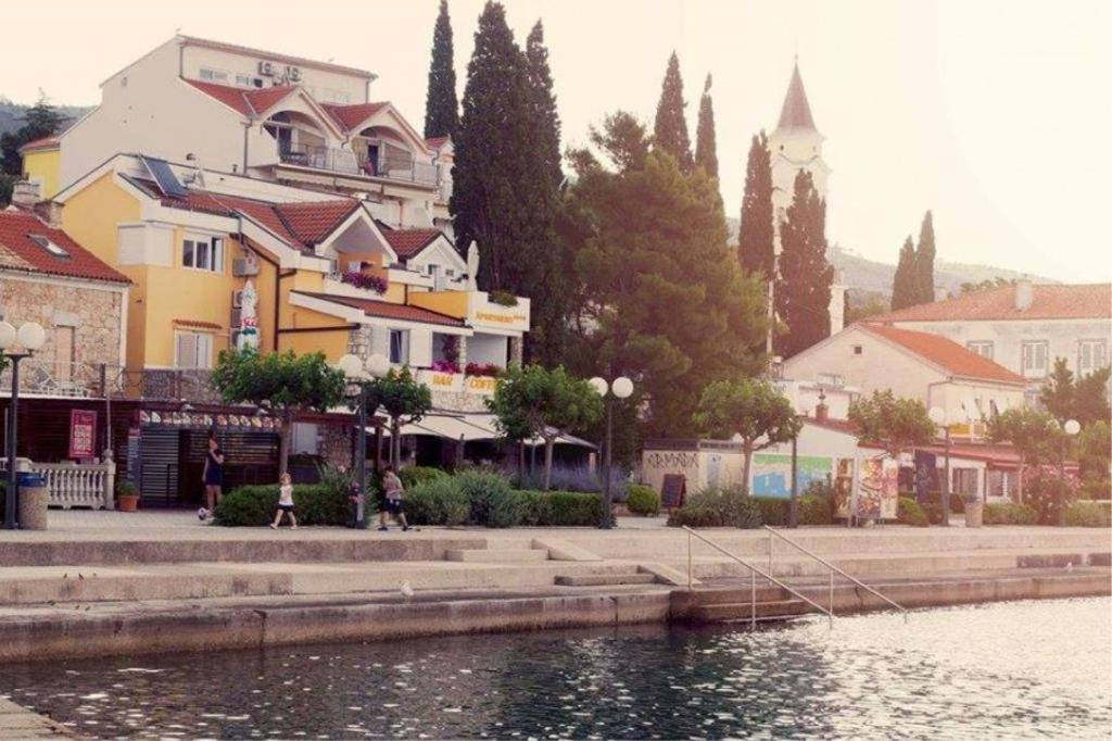 a building next to a body of water with buildings at Apartmani Jozinović in Selce