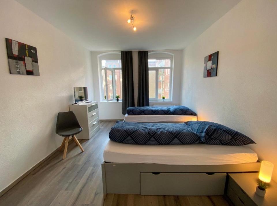 a bedroom with two beds and a desk at Neu saniertes Apartment in Magdeburg in Magdeburg