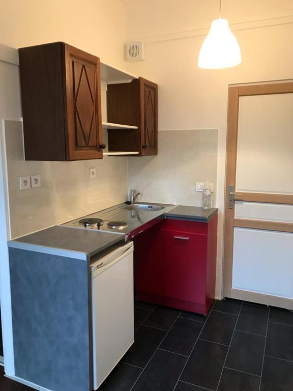 a kitchen with wooden cabinets and a counter top at Studio Stade de France RER B in Aubervilliers