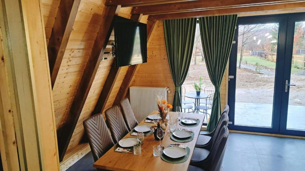 a dining room with a table and chairs and a large window at Cabana Evia Porumbacu de Sus in Porumbacu de Sus