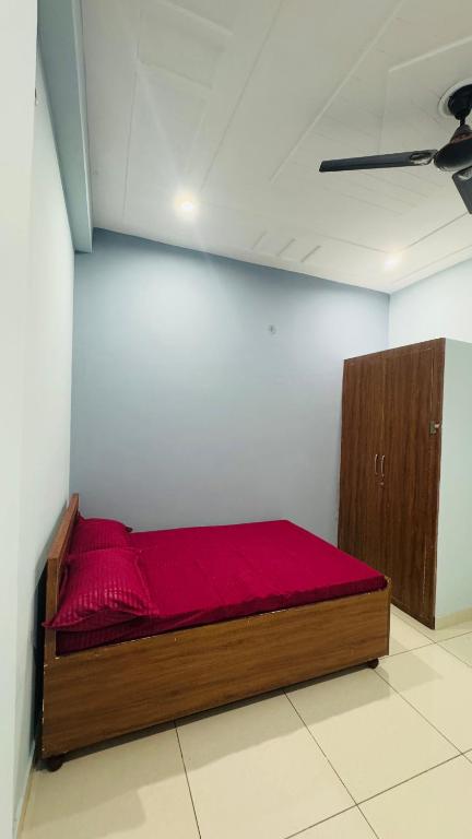 a bedroom with a bed with a red blanket on it at Diya Apartment in Rishīkesh