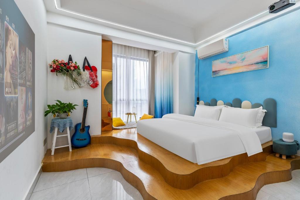 a bedroom with a white bed and blue walls at 张家界博亭安屿设计师民宿 in Zhangjiajie