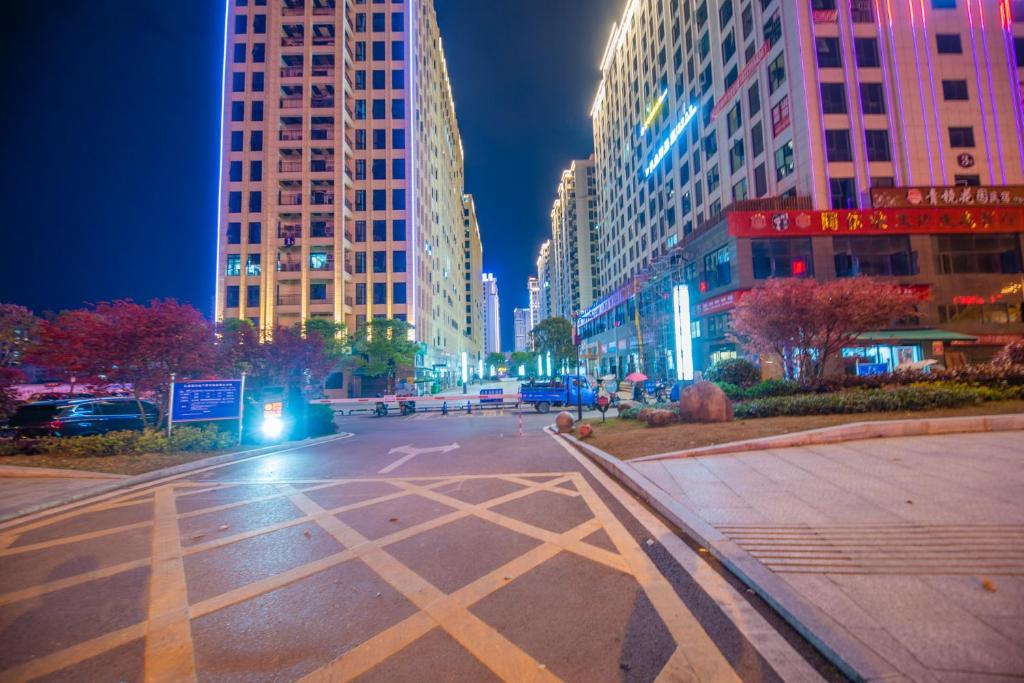 an empty city street at night with tall buildings at 张家界博亭安屿设计师民宿 in Zhangjiajie