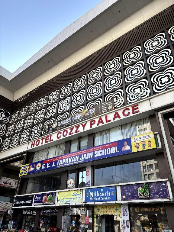a building with a sign for a hotel cavalry palace at Hotel Cozzy Palace in Surat
