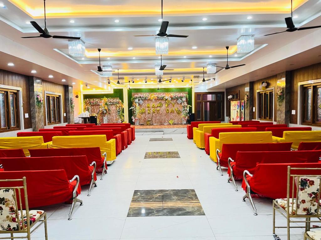 a conference hall with red and yellow chairs at HOTEL KINGDOM AND BANQUEt in Rūdarpur