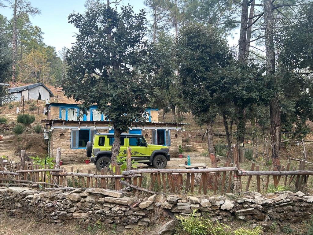 a yellow truck parked in front of a house at Glampinn Woods in Nainital