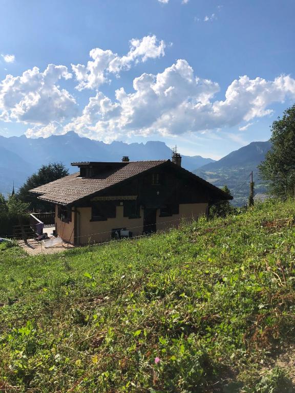 une maison sur le flanc d'une colline dans un champ dans l'établissement Chalet LA TOUPINE centre St Gervais, à Saint-Gervais-les-Bains