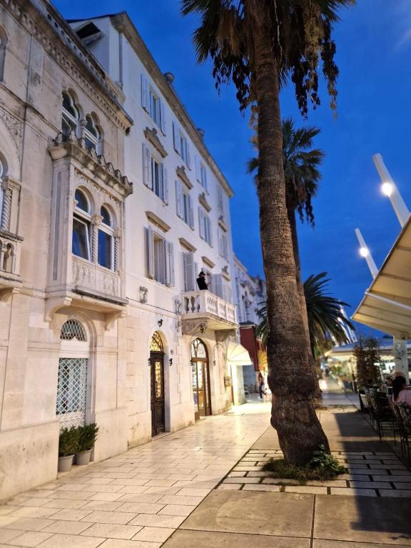 un edificio con una palma di fronte di Riva Luxury Suites a Spalato (Split)