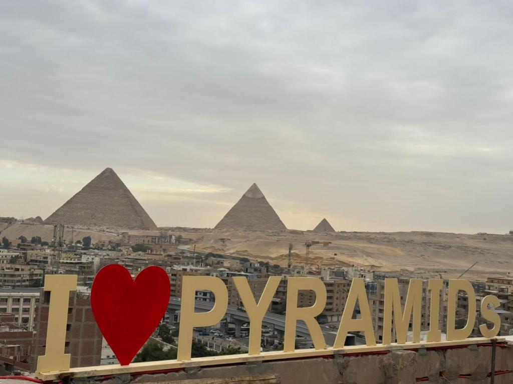 ein Zeichen, das Pyramiden mit rotem Herz liest in der Unterkunft Separate hotel rooms with a view of the pyramids in Kairo