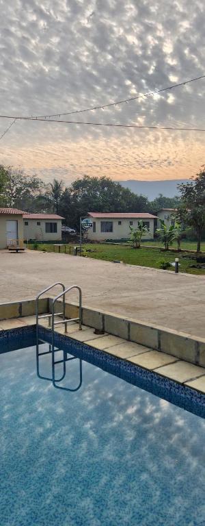 卡尔贾特Teak Resort Karjat的游泳池的景色,游泳池设有水中的梯子