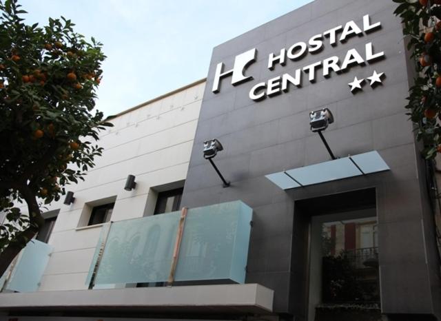 un bâtiment hospitalier avec un panneau sur son côté dans l'établissement Hostal Central, à Ceuta