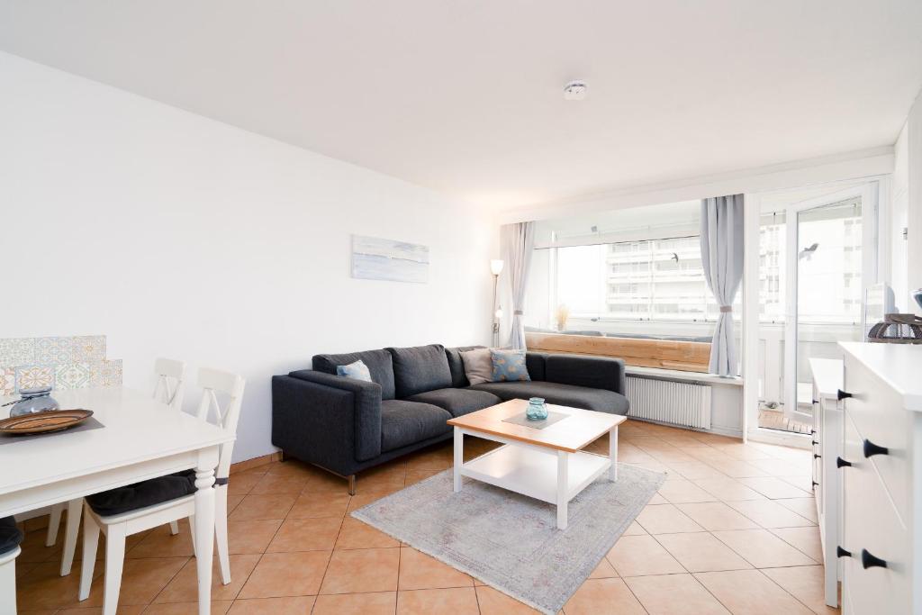 a living room with a couch and a table at Panoramic App B06-1 in Sierksdorf