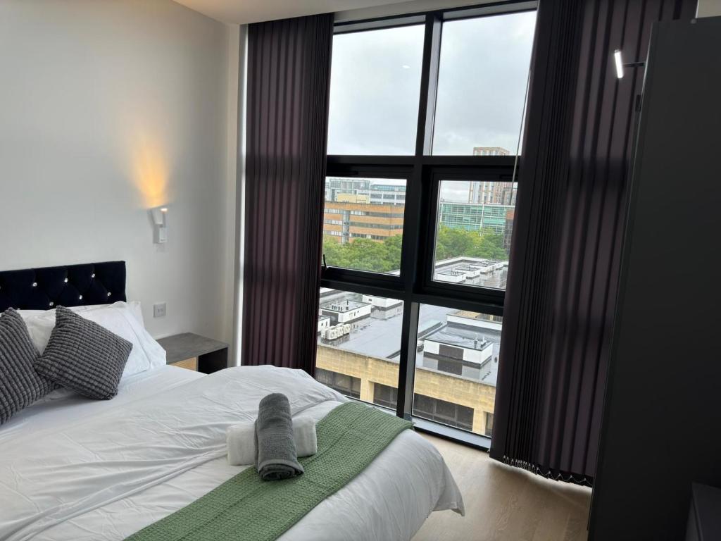 Un dormitorio con una cama y una ventana grande. en Elegant Apartment in Central Milton Keynes, en Milton Keynes