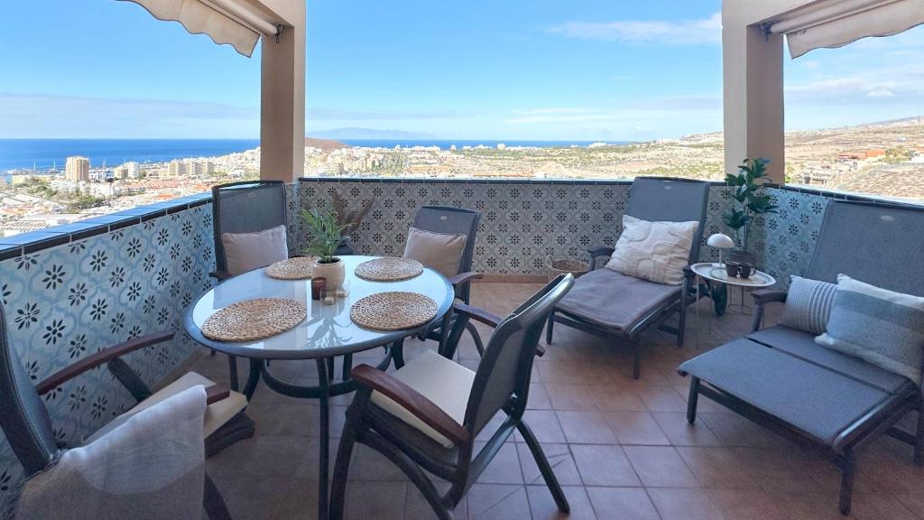 Un balcón con mesas y sillas y vistas al océano. en Alda apartment, en Los Cristianos