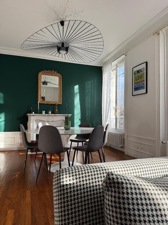 ein Wohnzimmer mit einem Tisch, Stühlen und einem Spiegel in der Unterkunft L'écrin des Tanneurs - 110m2 - 2 chambres - Epernay Hyper Centre in Épernay