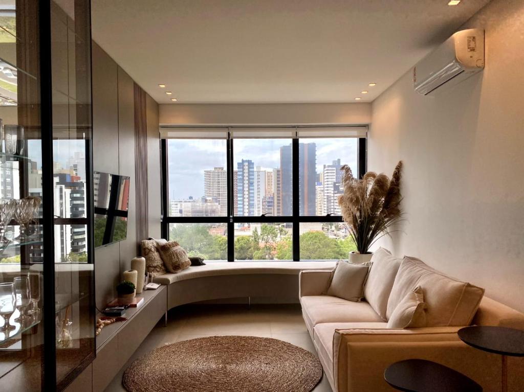a living room with a couch and a large window at Apartamento Torres RS in Torres