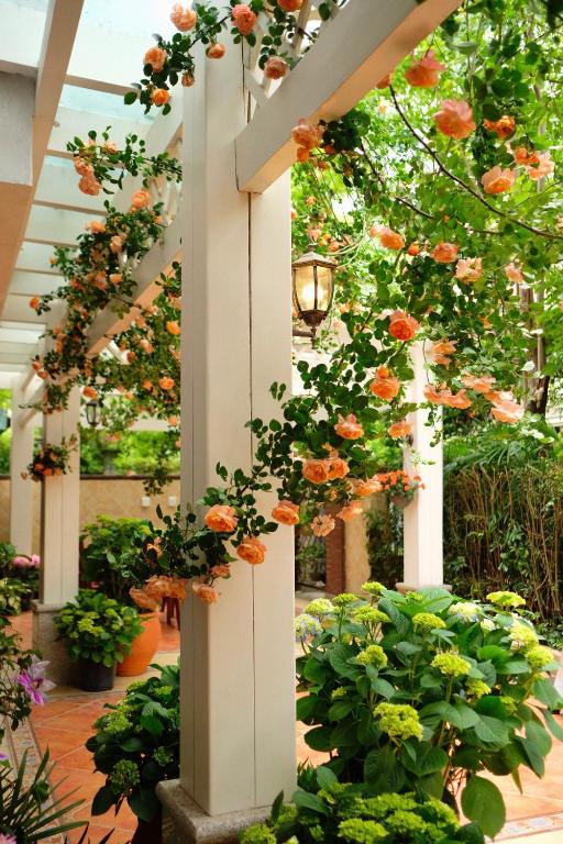 a garden with flowers hanging from a white column at 福来小院民宿 in Jiezi Ancient Town