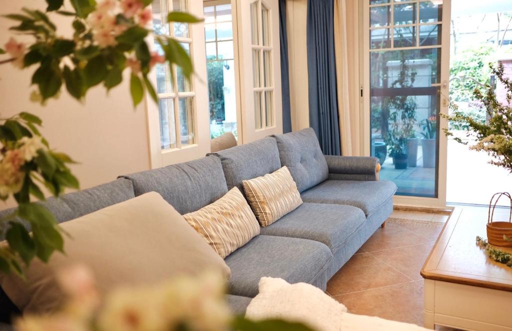 a living room with a blue couch and a table at 福来小院民宿 in Jiezi Ancient Town