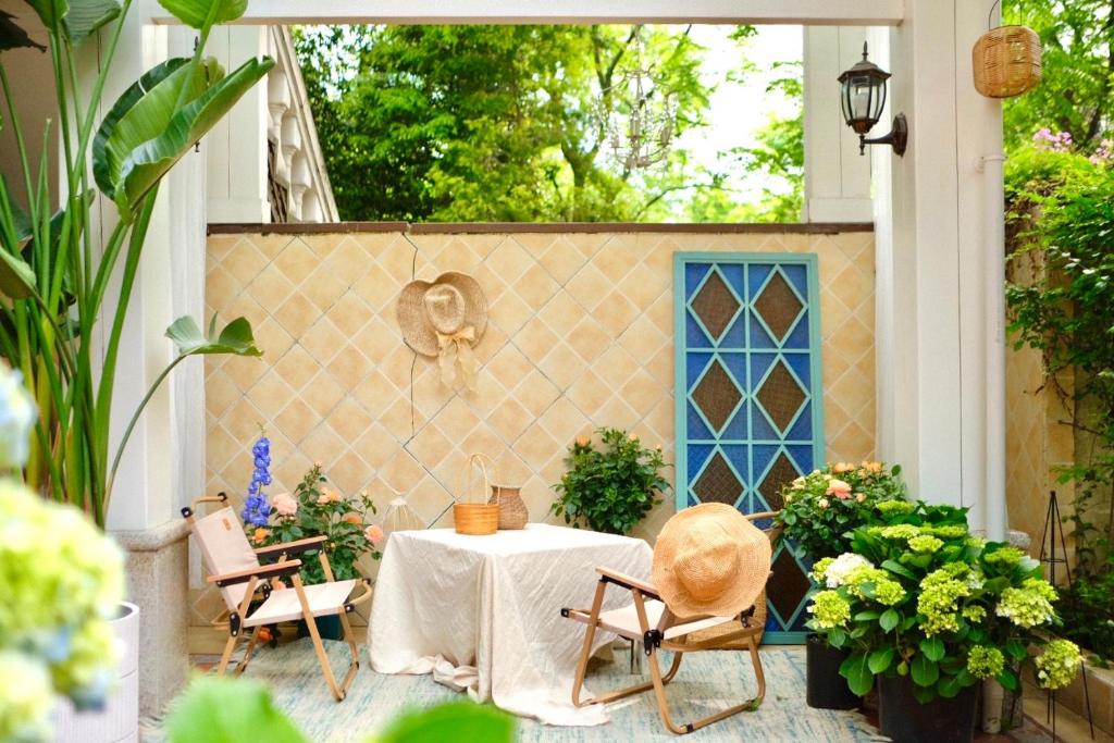 a patio with a table and chairs and plants at 福来小院民宿 in Jiezi Ancient Town