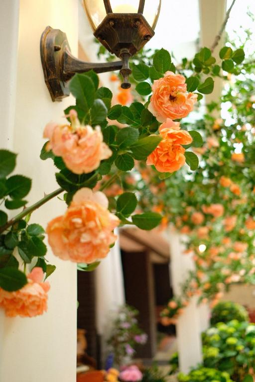 a bunch of orange roses hanging from a light fixture at 福来小院民宿 in Jiezi Ancient Town