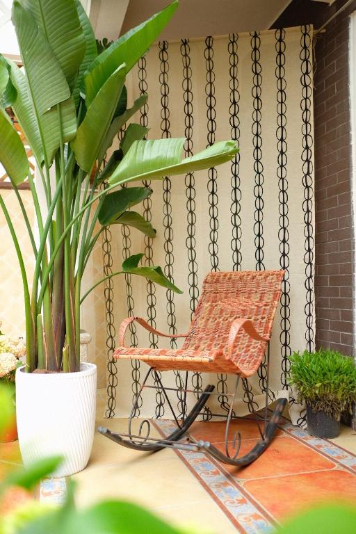 an orange chair sitting on a porch with plants at 福来小院民宿 in Jiezi Ancient Town