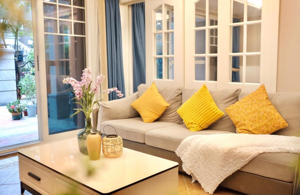 a living room with a couch with yellow pillows at 福来小院民宿 in Jiezi Ancient Town
