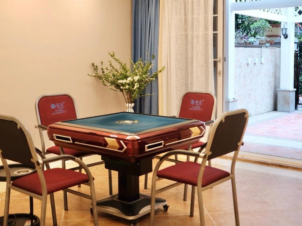a ping pong table with four chairs around it at 福来小院民宿 in Jiezi Ancient Town