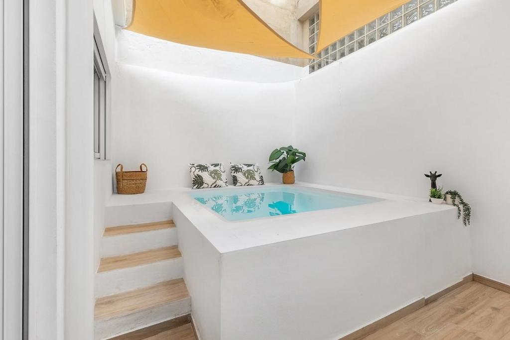 y baño con bañera en una pared blanca. en Urban Chic Oasis with AC, Private Pool and Wifi, en Alicante