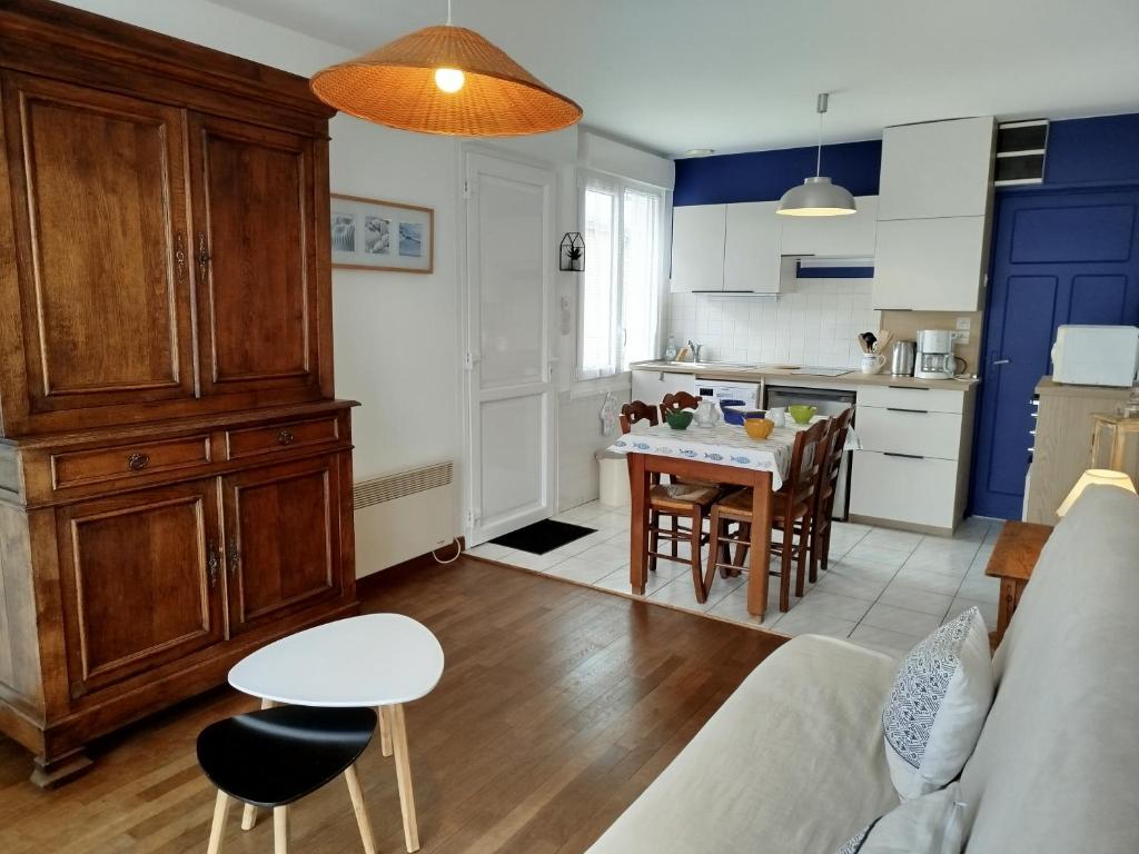 une cuisine et un salon avec un canapé et une table dans l'établissement gite notre désir 100 m de la mer, à Jullouville