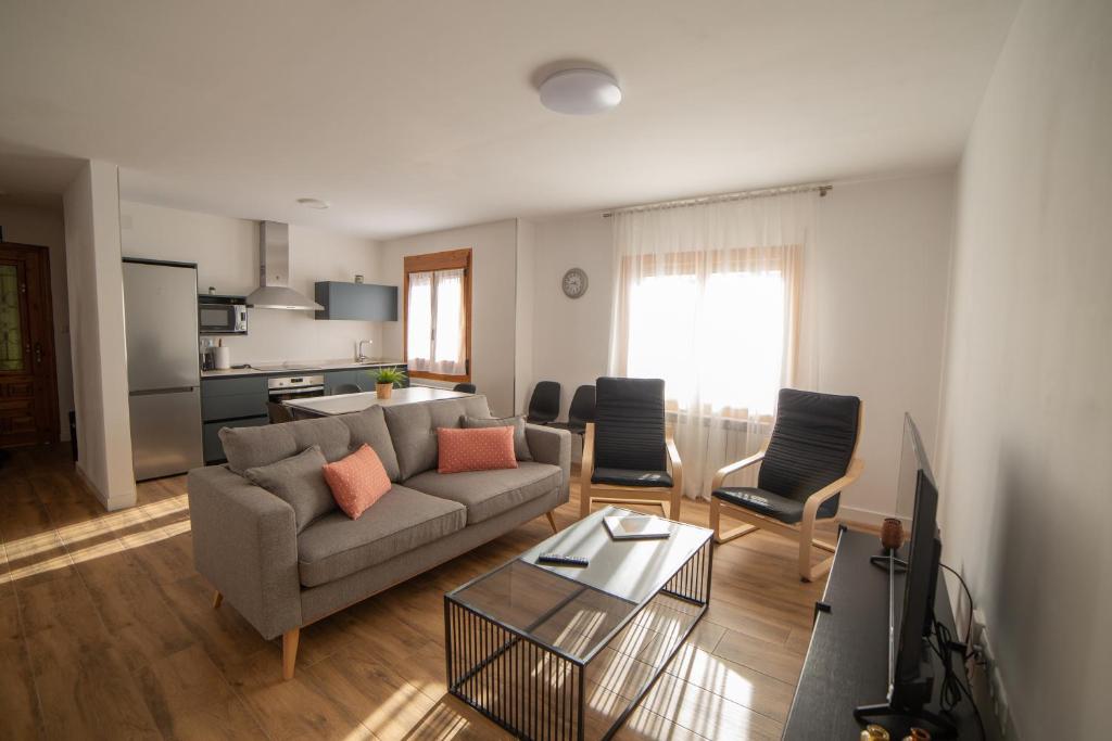 ein Wohnzimmer mit Sofa und Tisch in der Unterkunft Casa Tierra Viva, junto a Bardenas Reales y Sendaviva in Valtierra