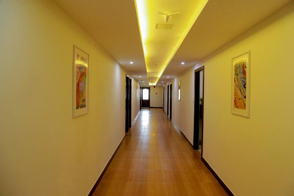 a hallway with a long hallway with a ceiling at Club 99 Suites in Ernakulam
