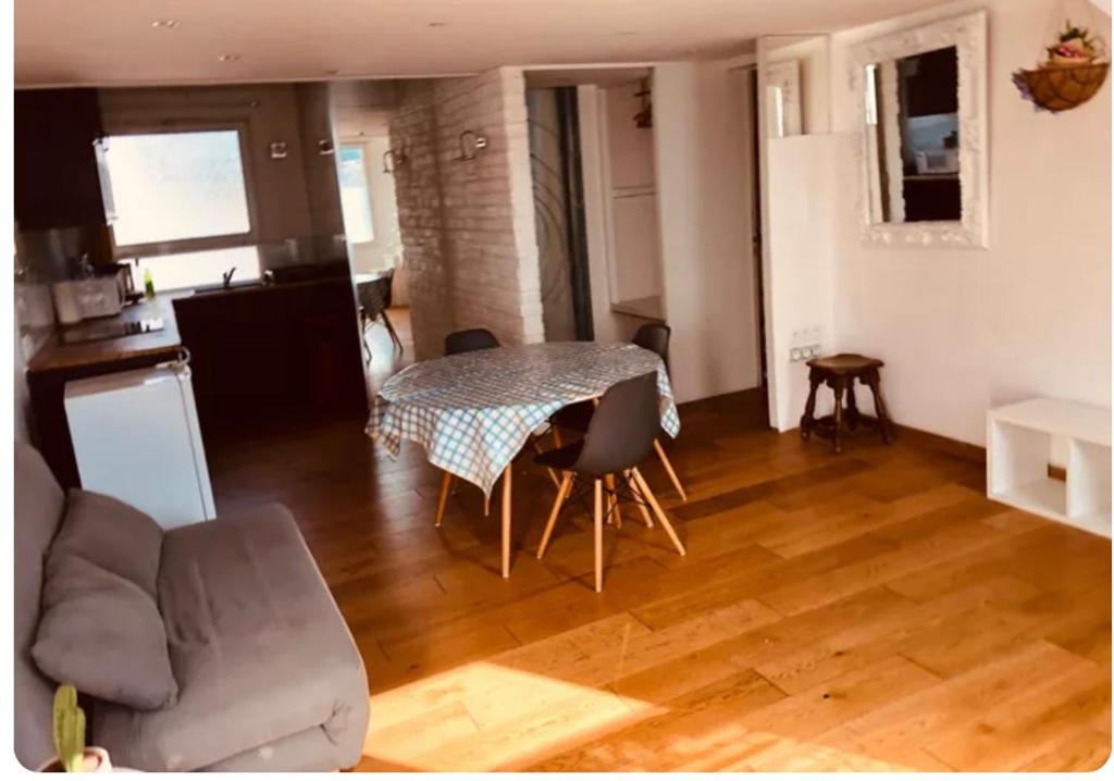 un salon avec une table et un canapé dans l'établissement Studio lumineux avec mezzanine, à Lagord