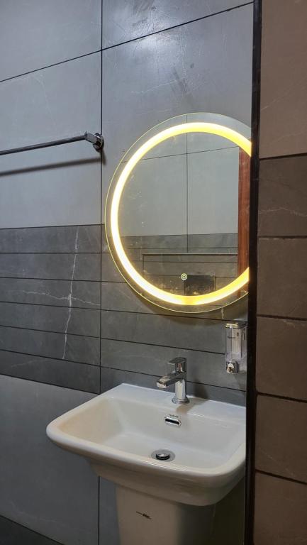 bagno con lavandino e specchio a parete di Hill View Homes,AC Suites in trivandrum a Trivandrum