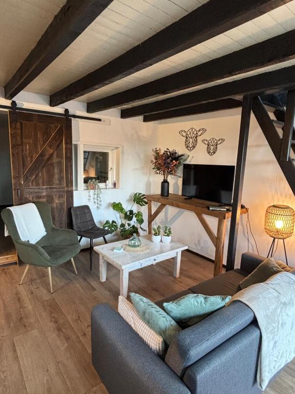 a living room with a couch and a table at Appartement de Schaapskooi in Heinkensand