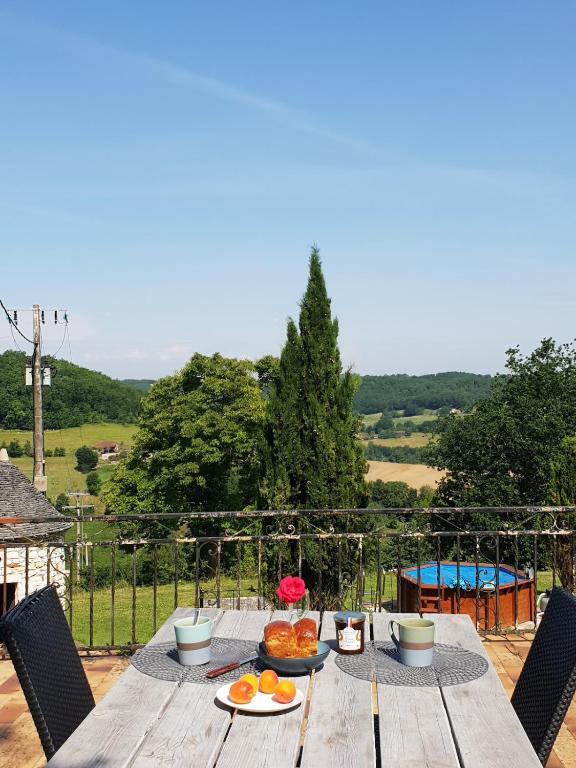 une table en bois avec une assiette de nourriture dessus dans l'établissement Gîte avec vue, à Hautefage-la-Tour