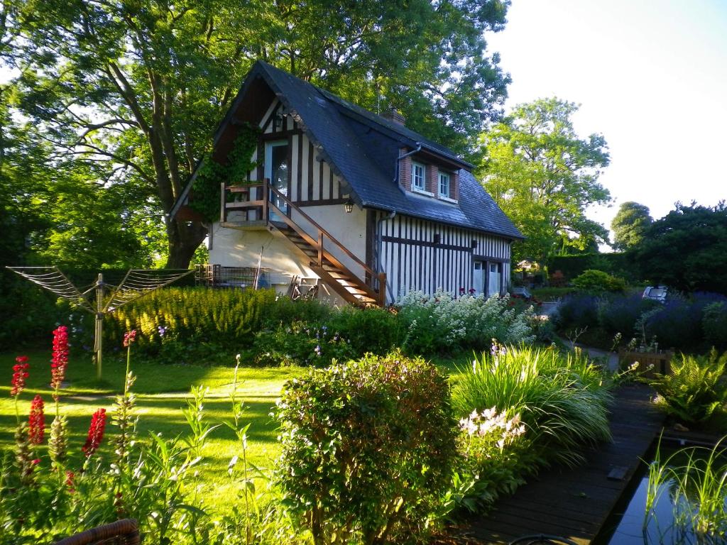 una casa con techo negro en un jardín en Gîte de l'Augérois en Fatouville-Grestain