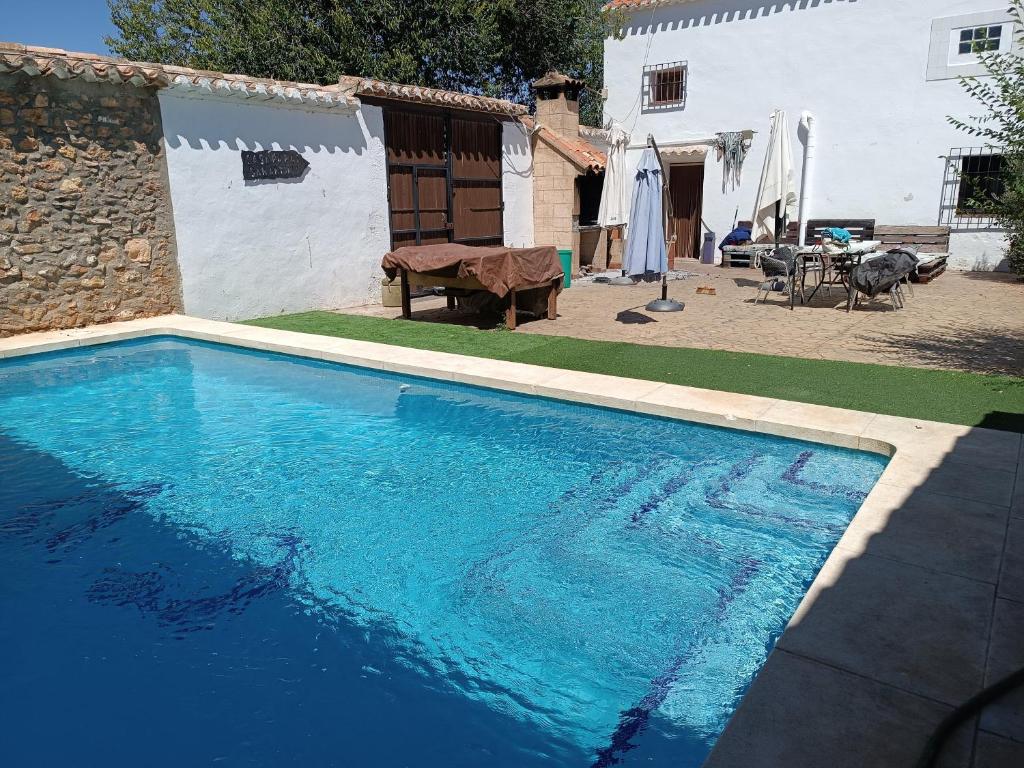 a large blue swimming pool next to a house at San Antonio 4 vientos in Pétrola