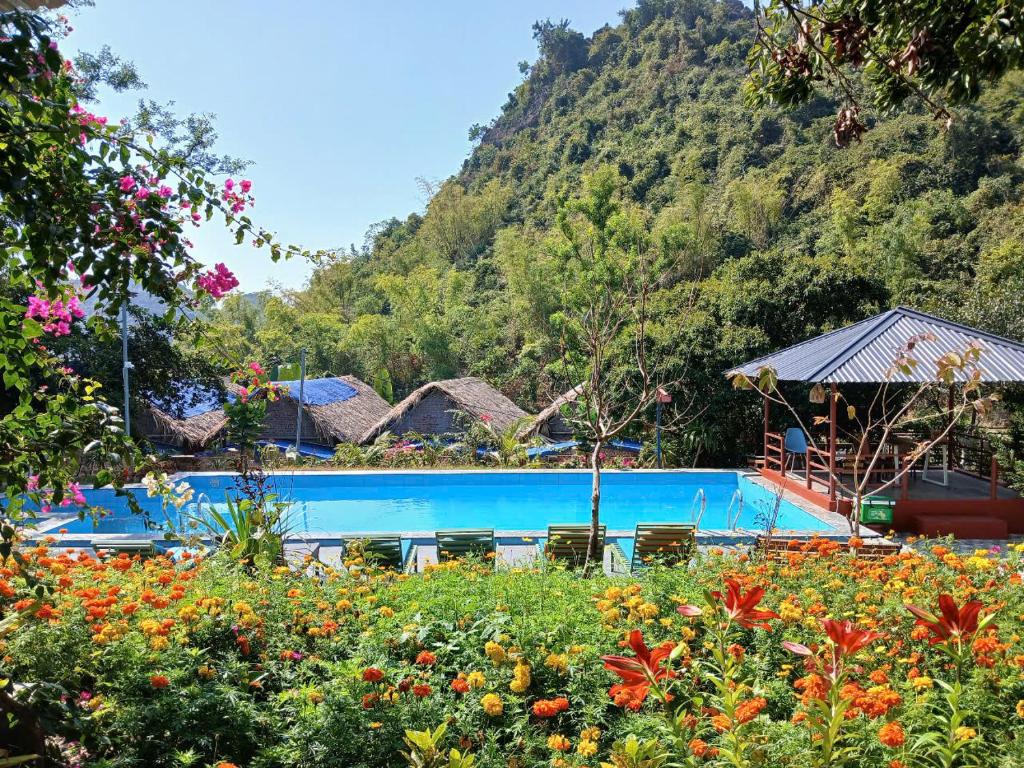a swimming pool in front of a mountain at Catba Papillon Garden Bungalows & Resort in Cat Ba