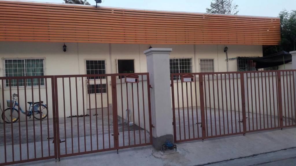 un edificio con una valla y una bicicleta delante de él en บ้านเช่าดีๆเงียบสงบที่ลงตัว, en Ban Lat Tanot