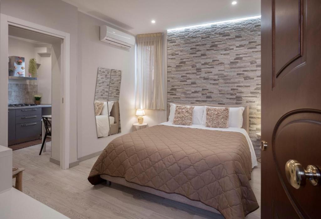 a bedroom with a bed and a brick wall at TaoZen Apartments in Taormina