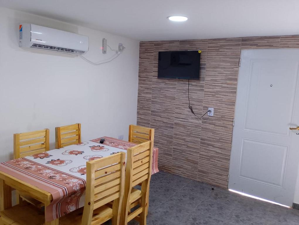 a dining room with a table and chairs and a television at La casita de bolson in El Bolsón