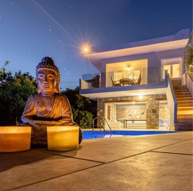 a large statue sitting in front of a house at Villa Neli II in Achlia