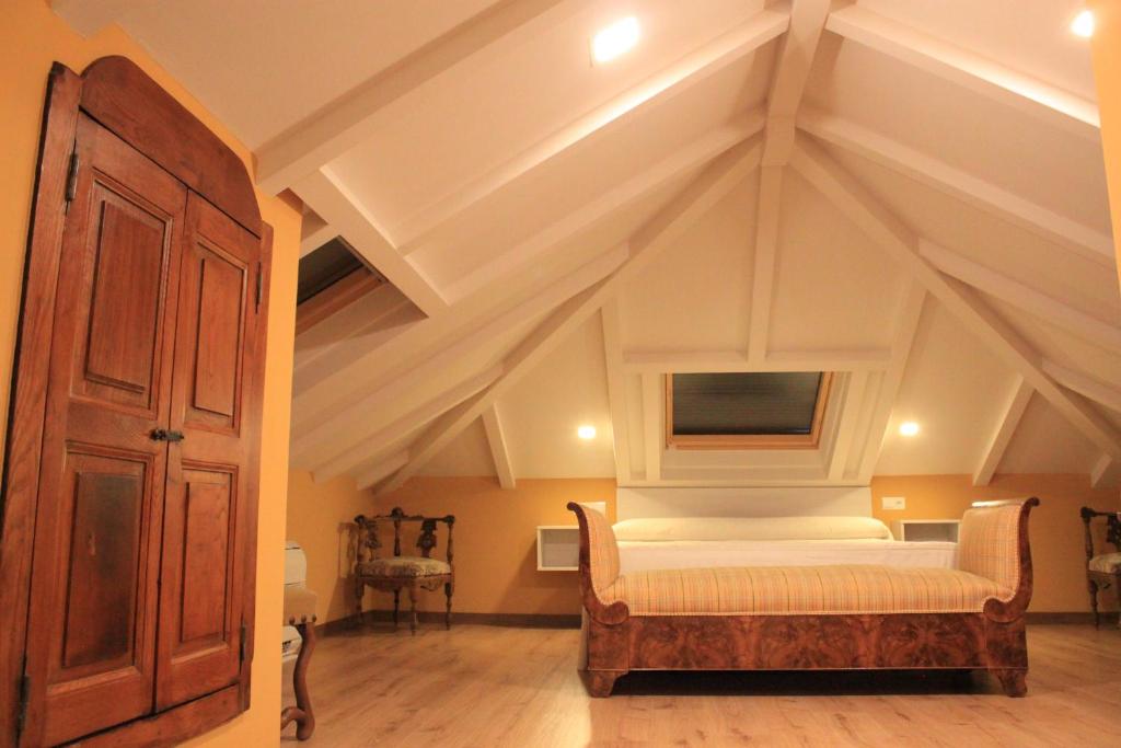 1 dormitorio con 1 cama y TV en el techo en Hostal Siglo XIX, en Cacabelos