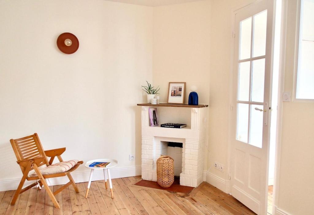 - un salon avec une cheminée blanche et une chaise dans l'établissement Astrée, Appartement 2-4 pers hyper-centre le touquet, à Le Touquet-Paris-Plage