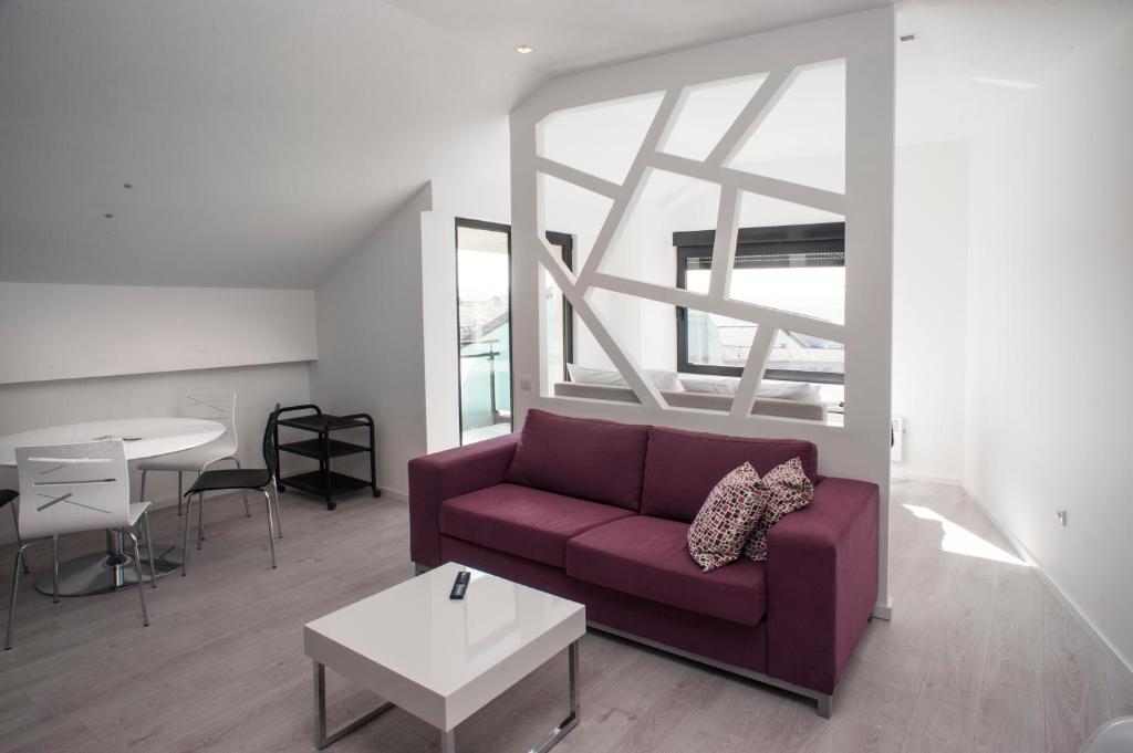 een woonkamer met een paarse bank en een tafel bij Apartments Villa Savamala in Belgrado