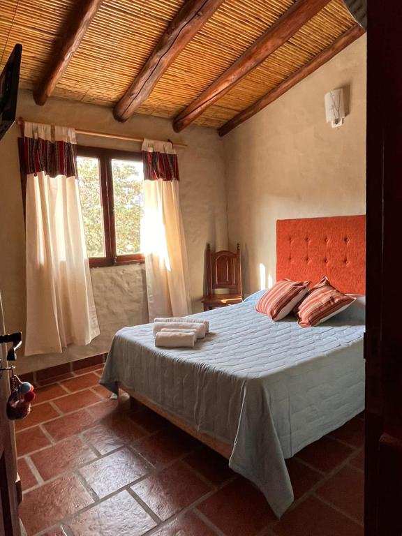 a bedroom with a large bed in a room with windows at Hotel La Herencia in Tilcara